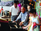 85岁的段柳香老人（前左二）带领孩子们参观旧式农具 [  摄影：燕雁 ]